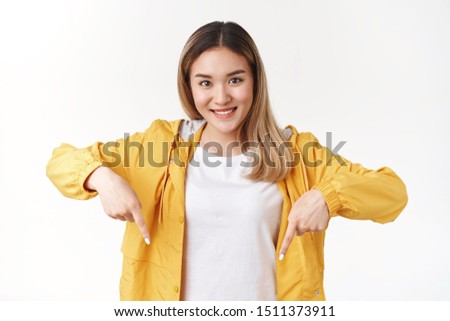 You cannot find better offer. Attractive cheerful silly blond asian girl pointing down index finger look camera happy optimistic smile propose good recommendation standing white background