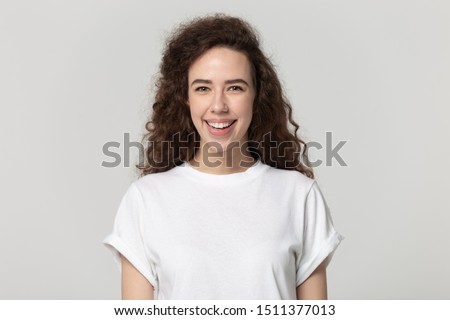 Head shot close up portrait millennial happy smiling attractive woman looking at camera. Healthy satisfied pretty female student or client posing for photo isolated on grey white studio background.