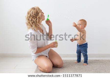 Family and childhood concept - Portrait of mother and baby playing and smiling at home.