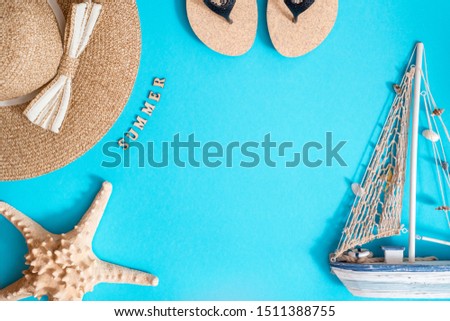 Accessories for summer on bright blue background. Summer hat, beach sandals, shopping bag with shells and starfish. Creative flat lay.Sea children's boat made of shells. Top view. copy space