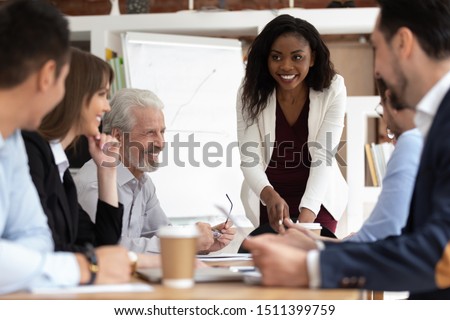 Different ethnicity and age businesspeople gathered together at boardroom for negotiations and planning future collaboration lead by african smiling businesswoman or corporate training process concept Royalty-Free Stock Photo #1511399759