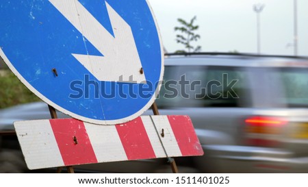 roadworks directional arrow sign on UK motorway at evening with traffic passing