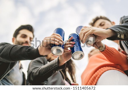 Group of young people toasting with canned beers. View from bottom, focus on the cans. Royalty-Free Stock Photo #1511405672