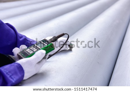 Inspector measuring thickness the pipe with UTM (Ultrasonic thickness measurement).  Selective focus on the inspection areas. Royalty-Free Stock Photo #1511417474