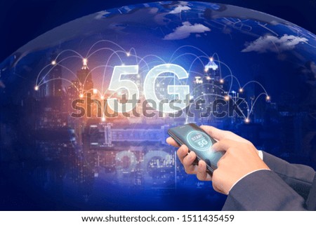 Creative background, male hand holding a phone with a 5G hologram on the background of the city. The concept of 5G network, high-speed mobile Internet, new generation networks. Mixed media.