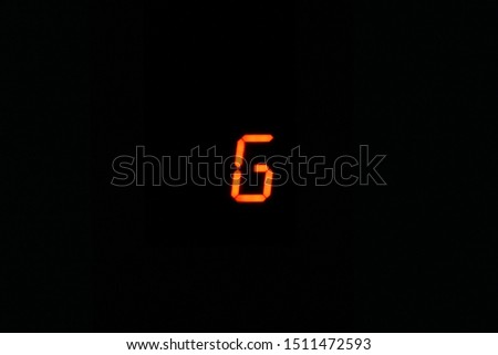 the letter G in red against dark , black background