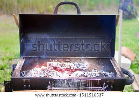 New modern barbecue grill with burning coals in nature