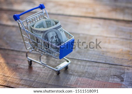 Shopping cart full pile of paper money, ecommerce trolley with cash stack, concept of online internet sale, income, saving, commercial