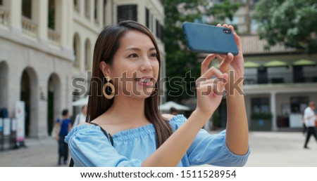 Woman tourist visit Hong Kong city and take photo on smart phone