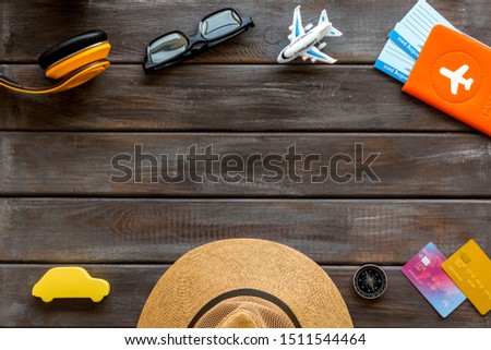 Travelling background with tourist accessories on dark wooden table top view space for text frame