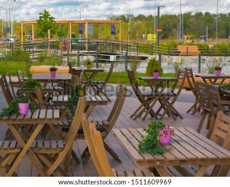 Outdoor cafe. Wooden tables and chairs. Summer beautiful background.Beautiful design.