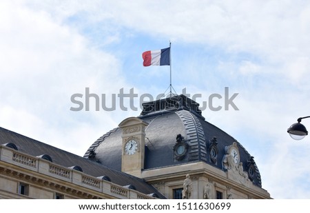 French flag on the top of the Ecole Militaire (Military School). Champ de Mars, Paris, France.