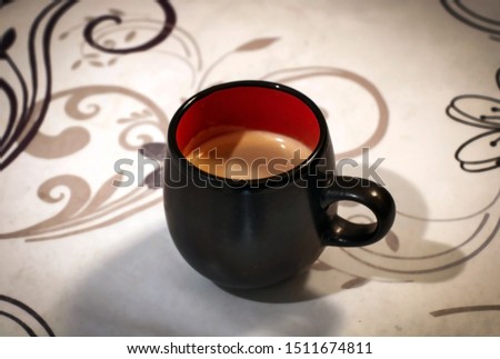 Black cup with coffee on the table