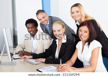 Businessman Showing On Computer To His Colleagues Royalty-Free Stock Photo #151169294