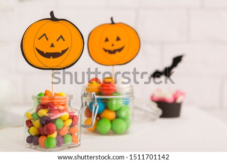 Halloween colorful candies with paper pumpkins for entertainment on party
