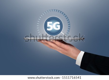 Man holding a digital tablet with symbol of 5G network connection.