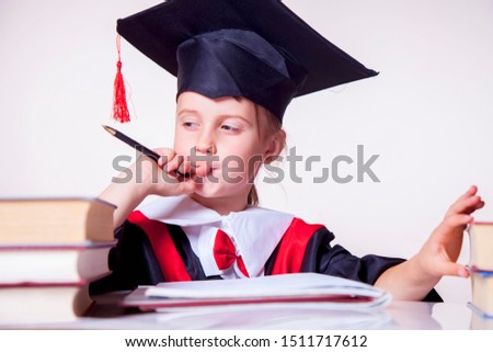 Child girl college graduate thinking about her perspectiv and future job. Humorous photo. (Knowledge, studies, work, career concept)