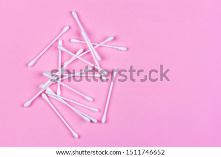 cotton swabs on light pink background top view with copy space