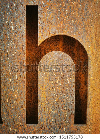 close up of rusty steel cut out of letter h lower case