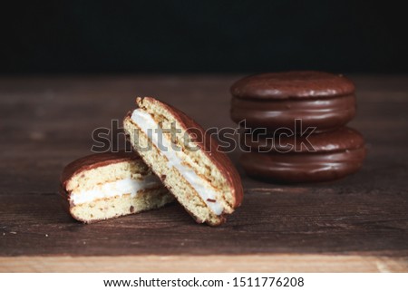 Chocolate chip cookies on a dark wooden table. Cookies cut in half. Background image. Tasty breakfast.