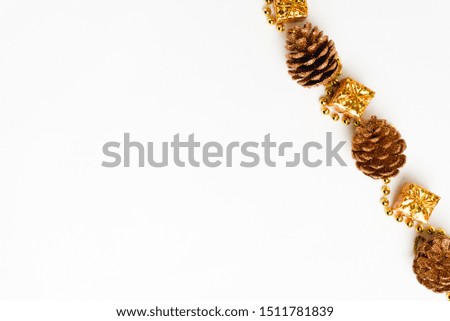 Christmas composition. Christmas golden decor, pine cone, gift on white background. Flat lay, top view, copy space