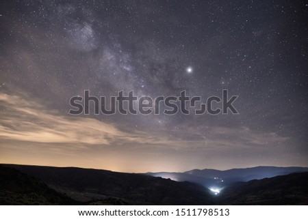image of the milky way galaxy over a small town on a summer night