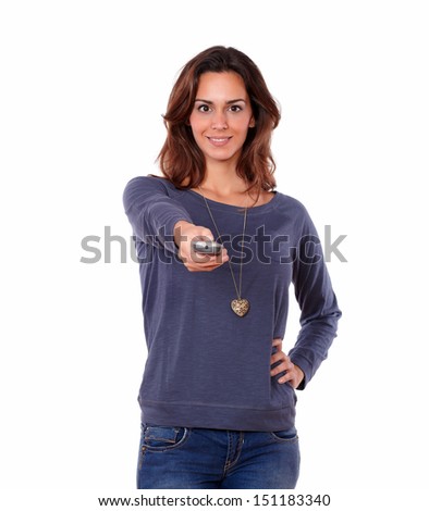 Portrait of a gorgeous young woman pointing the remote control on white background