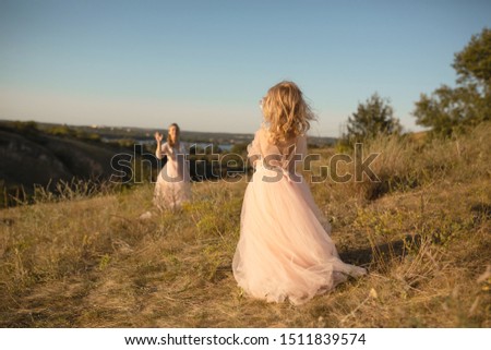 A little girl in a pink princess dress goes to meet her mom.