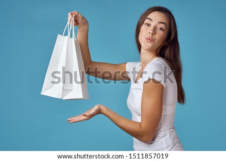 white packets blue background beautiful woman dark hair cropped view Shopping             