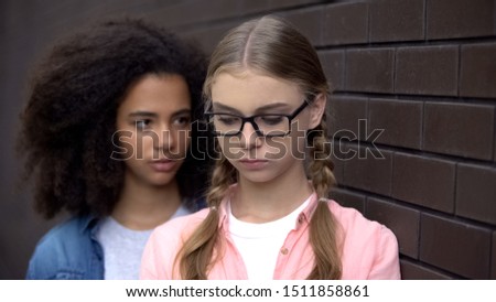 Cruel black student bullying caucasian schoolgirl eyeglasses, emotional pressure Royalty-Free Stock Photo #1511858861