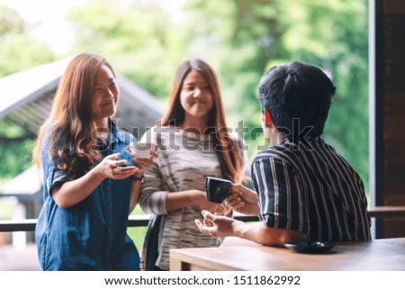 Closeup image of three people enjoyed talking and drinking coffee together in cafe
