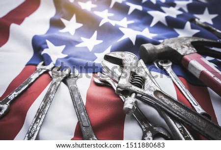 Happy Labor day. Wrench engineer constructor tools on american flag.