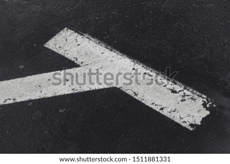 white painted parking zone diagonal marker on textured asphalt surface
