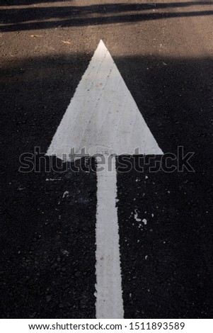 white arrow  sign strait direction on the street