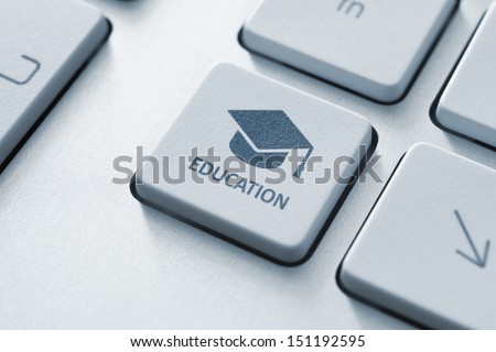 Button with graduation cap icon on a modern computer keyboard. Online education concept.
