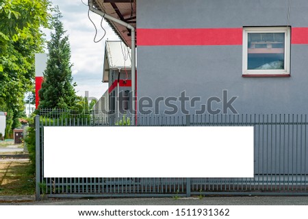 Blank white banner for advertisement on the fence of warehouse building