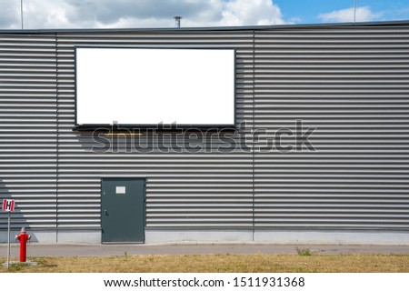 Blank white advertising billboard on wall of the industrial building