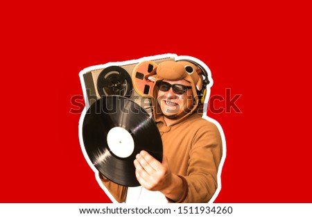 Man in cosplay costume of a cow with reel tape recorder isolated on red background. Guy in the animal pyjamas sleepwear. Funny photo with party ideas. Disco retro music.
