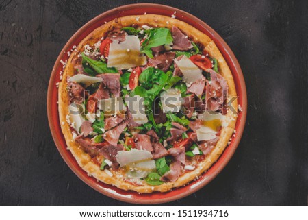 mixed and eggplant pizza on the white and black wooden background. 