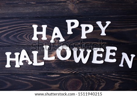 Halloween and decoration concept . White halloween inscription with small colored sweets.