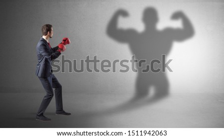 Businessman fighting with his bossy yelling shadow
