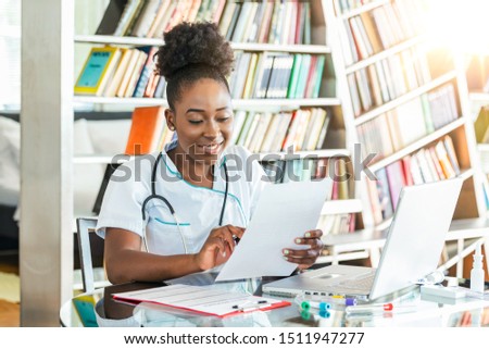 Doctor's working on laptop computer, writing prescription clipboard with record information paper folders on desk in hospital or clinic, Healthcare and medical concept.