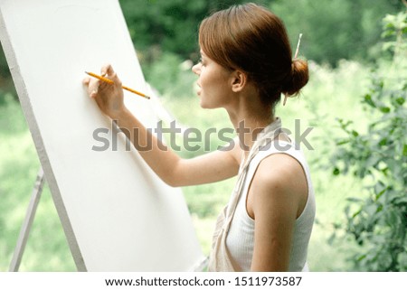 woman on a white canvas draws an easel