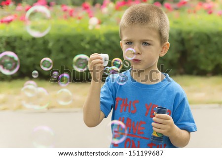 Boy Blowing Soap Bubbles 