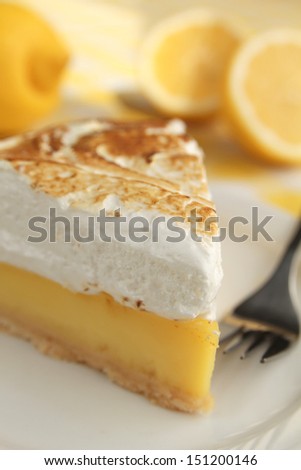 Lemon pie with meringue and a fork in a plate