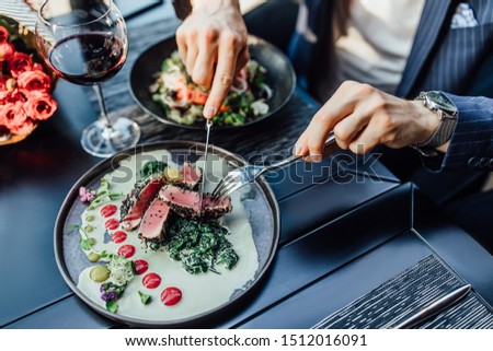 Close up photo, man ready to eat medium rare beef steak while sitting in modern restaurant.