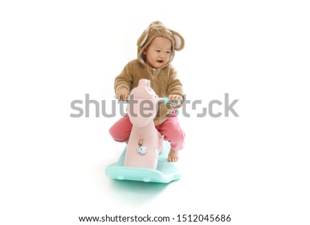 Cute baby riding a wooden horse with a white background              