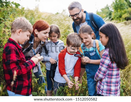 Group of school children with teacher on field trip in nature, learning science. Royalty-Free Stock Photo #1512050582