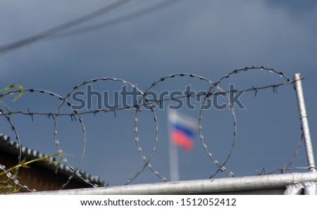 Prison fence with barbed wire in a Russian prison Royalty-Free Stock Photo #1512052412