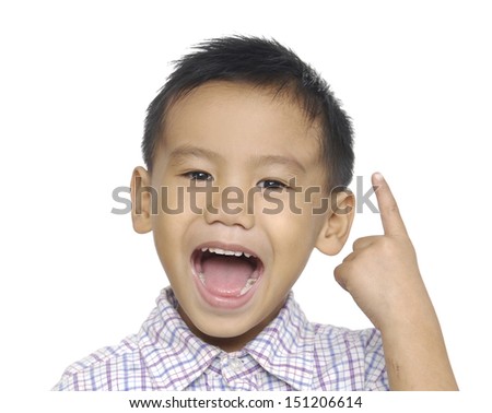 Little boy in round spectacles raising finger in funny attention gesture 